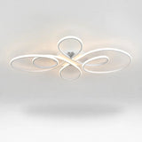 A modern ceiling light fixture with flowing, abstract oval loops in a glossy white finish, emitting a warm light glow against a clean white ceiling.