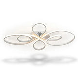 A modern ceiling light fixture with flowing, abstract oval loops in a brushed silver finish, emitting a warm white glow from its central LED light source, shown against a plain white background with a soft shadow below.