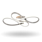 A modern three-ring LED ceiling light fixture with a polished chrome finish and a warm gold accent plate, shown floating against a solid white background.