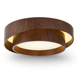 A modern circular flush-mount ceiling light fixture with a dark brown wood-grain outer ring, a warm glowing inner ring, and a white diffuser below, shown against a plain white background.