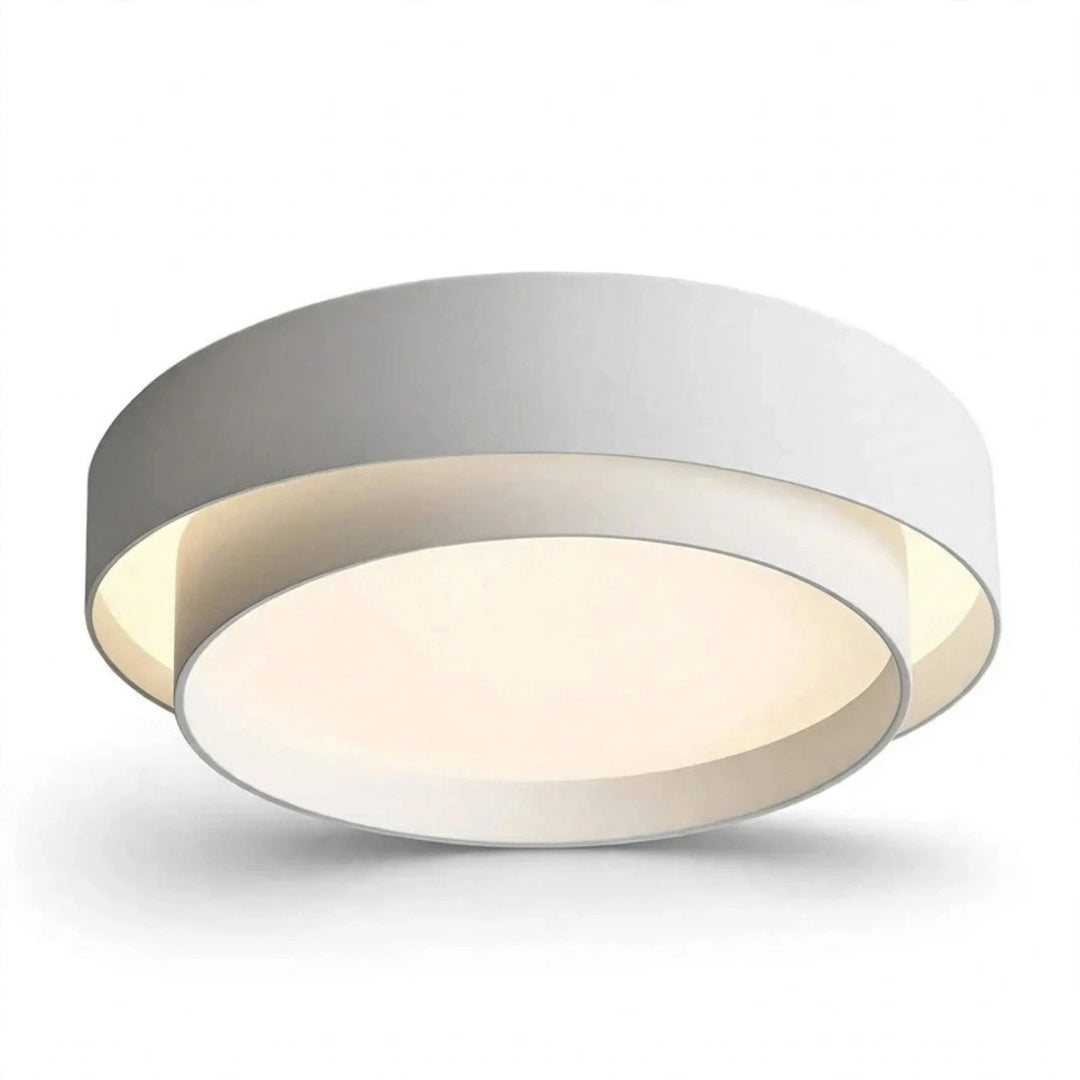 A modern circular flush-mount ceiling light fixture with a white outer ring, a warm cream-colored inner ring, and a silver metallic rim, shown against a plain white background.
