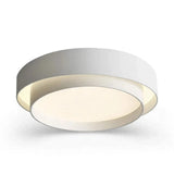 A modern flush-mount ceiling light fixture with a double-ring design, featuring a matte white outer ring, a white inner ring, and a warm cream-colored diffuser that glows with soft light.
