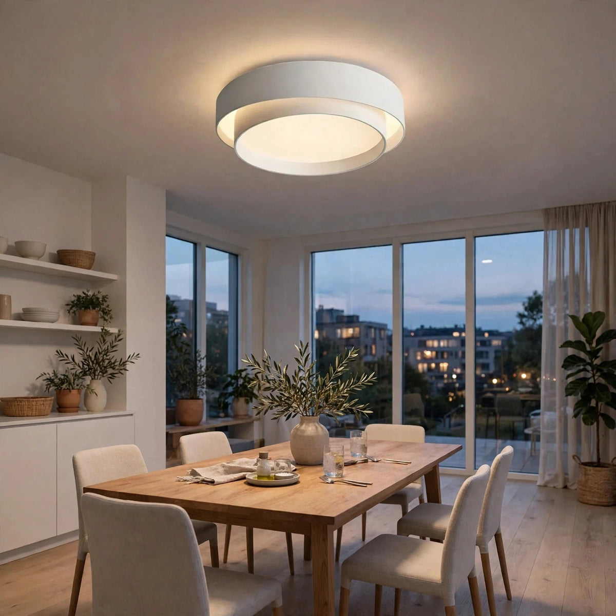 A white flush mount light with glowing circular rings sits above a wooden dining table surrounded by cream upholstered chairs.