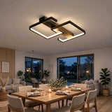 Modern geometric LED ceiling light fixture in a warm black finish, mounted on the ceiling of a contemporary dining room with a wooden dining table and chairs below.