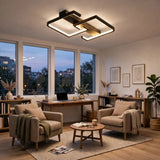 Modern geometric ceiling light fixture with black and gold metal frames and integrated LED lighting, shown installed in a contemporary living room with beige armchairs, a wooden desk, and large windows.