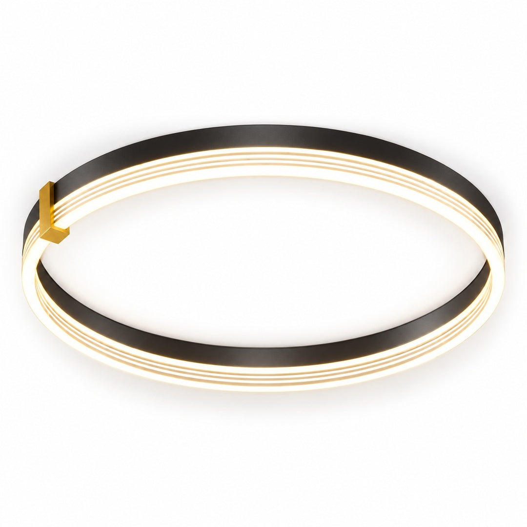 A modern circular LED ceiling light fixture with a black outer ring, three glowing warm white inner rings, and a small gold accent piece on the left side, shown against a plain white background.