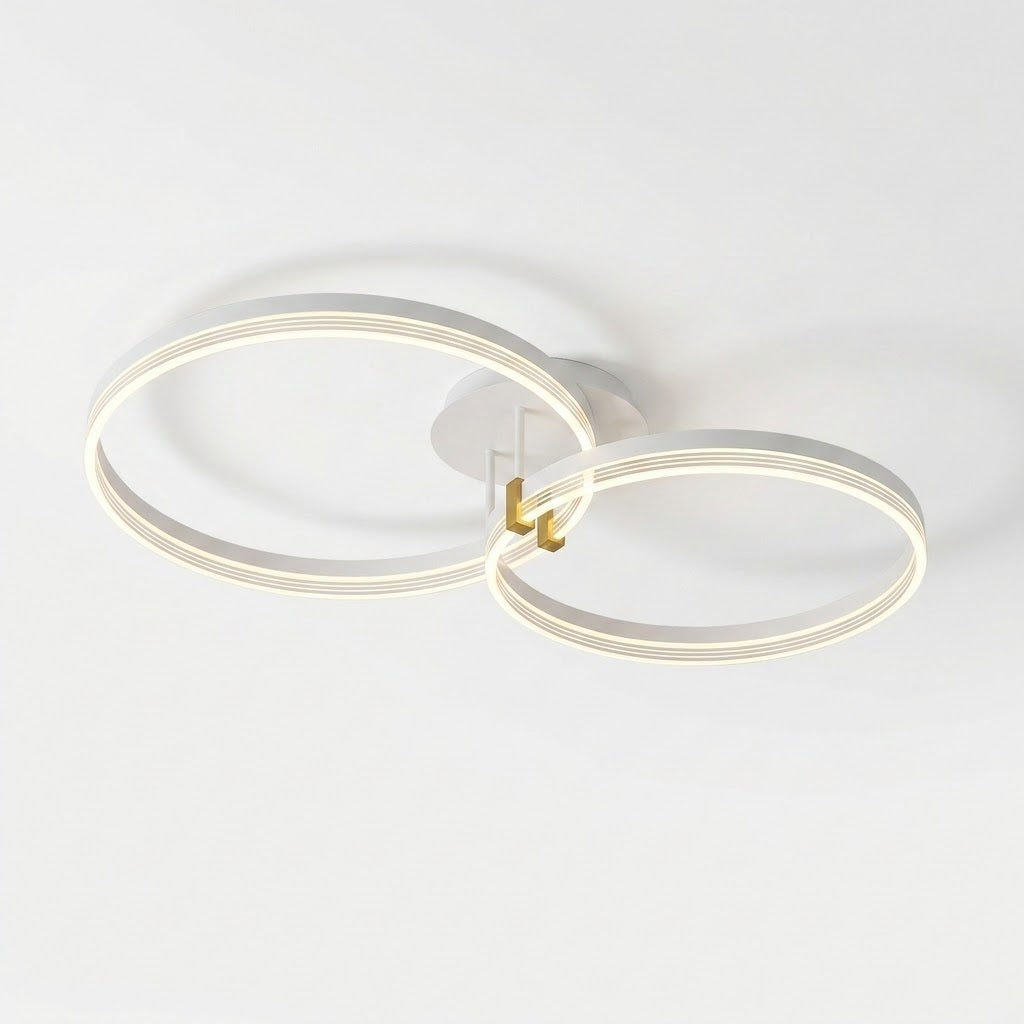 Modern ceiling light fixture with two interlocking circular LED rings in a white and gold finish, mounted on a plain white ceiling.