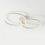 Modern ceiling light fixture with two interlocking circular LED rings in a white and gold finish, mounted on a plain white ceiling.