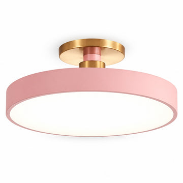 A modern semi-flush mount ceiling light featuring a wide pink cylindrical shade, a white diffuser inside, and a brushed gold metal ceiling mount and central collar.