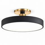A modern semi-flush mount ceiling light fixture featuring a matte black cylindrical shade and brushed gold metal hardware, shown against a solid white background.