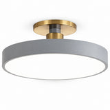 A modern semi-flush mount ceiling light featuring a wide, matte gray circular shade and a brushed brass metal ceiling mount, shown against a solid white background.