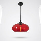 A modern pendant light with a glossy, rounded red glass shade and a matte black ceiling canopy and cord, shown against a light gray background.