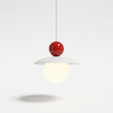 A modern pendant light with a glossy red spherical top, a white flat disc shade, and a glowing warm white globe bulb, suspended against a clean white background.