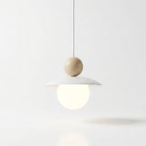 A minimalist pendant light with a white disc-shaped shade, a small beige wooden sphere, and a glowing frosted white globe bulb, suspended against a clean white background.