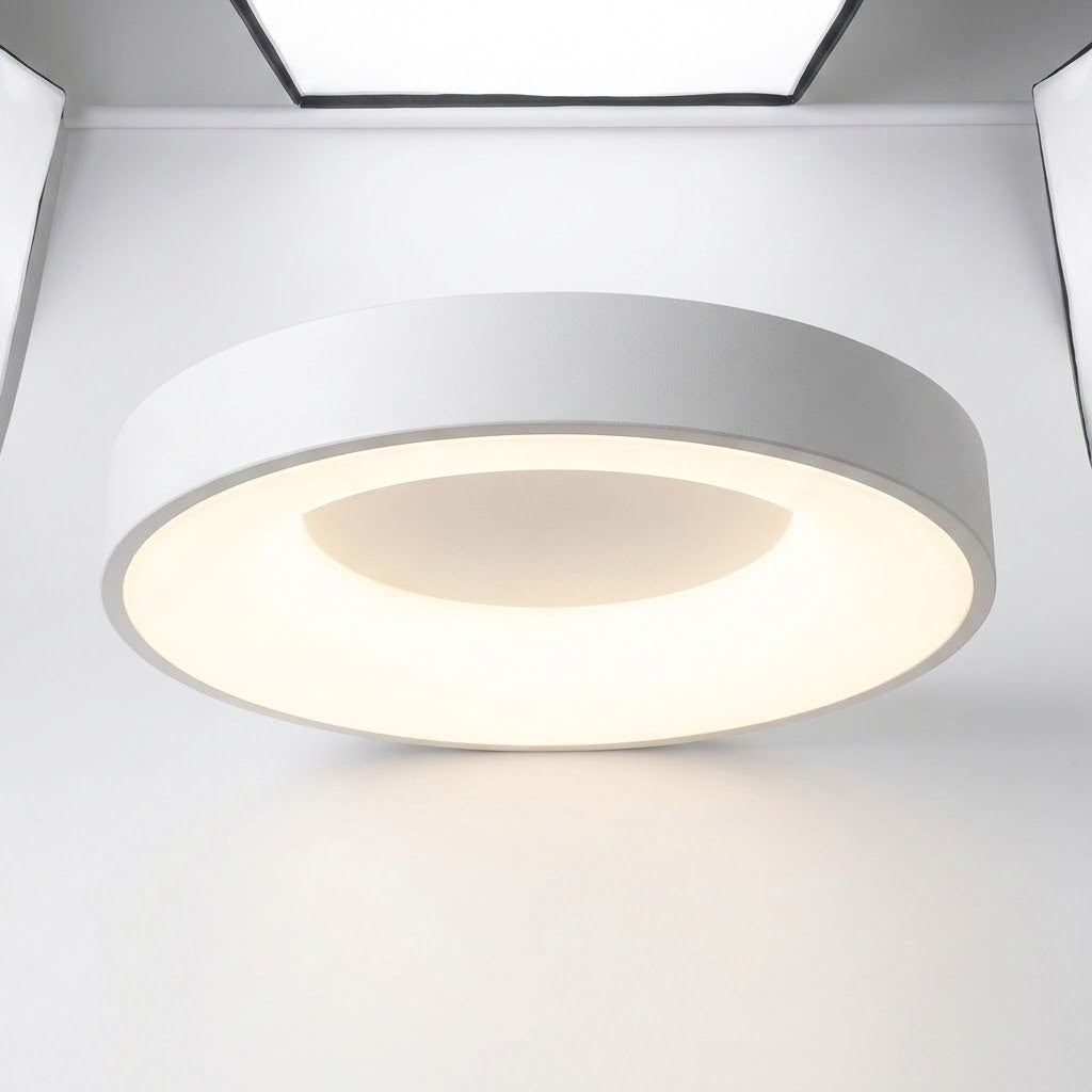 A modern circular flush-mount ceiling light fixture with a white outer ring and a warm white illuminated inner diffuser, shown installed on a white ceiling.