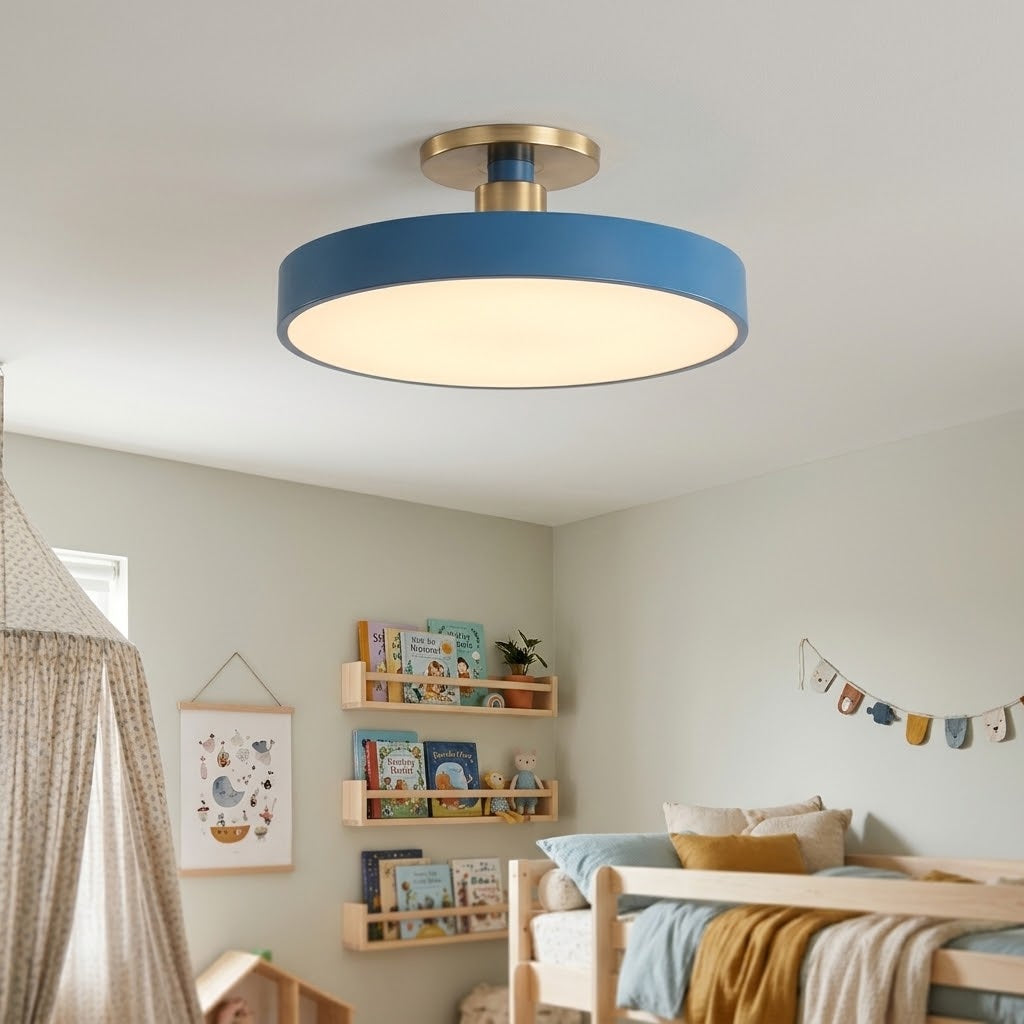 A modern semi-flush mount ceiling light with a matte blue outer ring, a warm white illuminated diffuser, and a brushed gold ceiling canopy, shown installed in a child's bedroom.