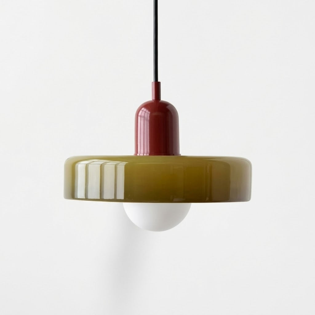 A modern pendant light with a translucent olive-green circular shade, a dark red central neck, a black hanging cord, and a white globe bulb below, shown against a plain white background.