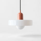 A modern pendant light with a wide white flared shade, a white dome diffuser below, and a terracotta-colored central connector on a black cord, shown against a clean white background.