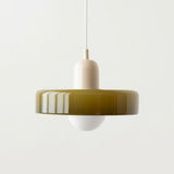 A modern pendant light with a glossy olive green circular shade, a cream-colored central neck, and a white globe bulb, suspended by a thin white cord against a plain white background.