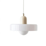 A modern pendant light with a wide, flared white glass shade, a cream-colored cylindrical neck, and a white hanging cord against a plain white background.