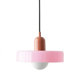 A modern pendant light with a wide, fluted pink shade, a glossy terracotta-colored central body, a black hanging cord, and a white globe bulb below, shown against a plain white background.