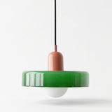 A modern pendant light with a glossy green circular shade, a terracotta-colored central stem, a black suspension cord, and a white glass globe bulb, shown against a plain white background.
