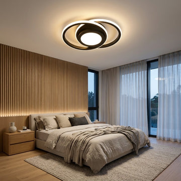 Modern bedroom featuring a circular black and white LED ceiling light fixture, a wooden slatted accent wall, a bed with neutral beige bedding, and large windows with sheer white curtains.