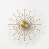 Gold metal ceiling light with a brushed circular center and alternating long and short illuminated rods against a white background.