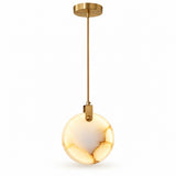 A chandelier features an illuminated cream marble disc with prominent amber veining along its right edge and gold fittings against white.