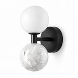 A modern wall-mounted sconce with a matte black circular backplate, horizontal arm, and vertical stem, featuring one matte white spherical globe and one white-and-gray marbled globe, shown on a plain white background.