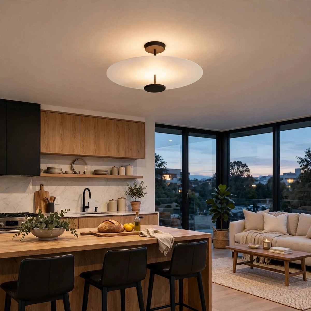 A modern ceiling light fixture with a circular white frosted glass shade and black metal accents, mounted in a contemporary kitchen and living room setting.