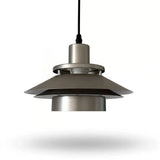 A modern pendant light fixture with a brushed metal finish, featuring a wide conical shade and a black hanging cord, shown against a plain white background.