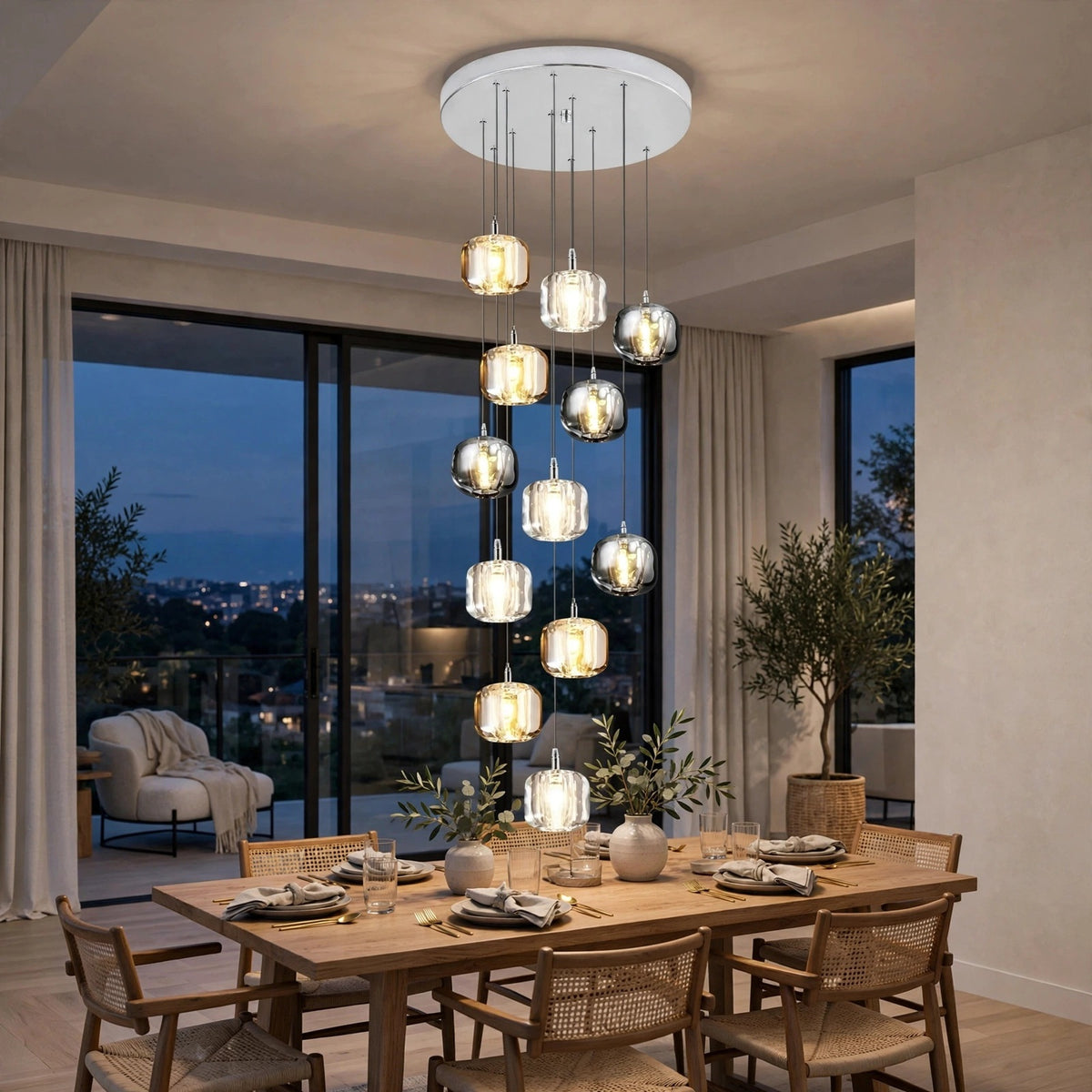 A modern multi-light chandelier with clear glass cylindrical pendant shades hangs over a wooden dining table in a contemporary dining room at dusk.