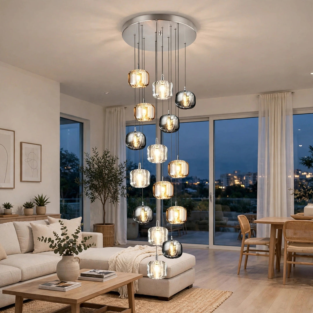 A modern multi-light chandelier with multiple glass pendant shades hangs in a bright, contemporary living room with large windows overlooking a city skyline at dusk.