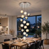 A modern multi-light chandelier with multiple glass globe shades in amber, gold, and clear tones, hanging over a wooden dining table in a contemporary dining room.