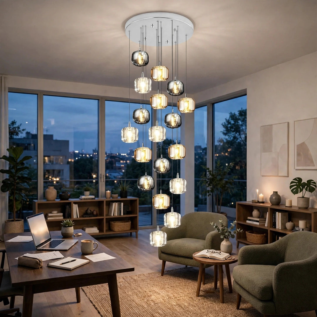A modern multi-light chandelier with clear glass and metallic spherical shades hangs in a stylishly furnished living room with large windows overlooking a city skyline at dusk.