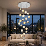 A modern multi-light chandelier with multiple glass globe shades of varying sizes hanging from a circular white ceiling mount in a contemporary living room.
