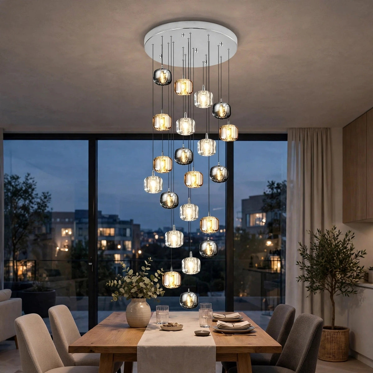 A modern multi-light chandelier with clear glass and metallic spherical bulbs hangs over a dining table in a contemporary dining room at dusk.
