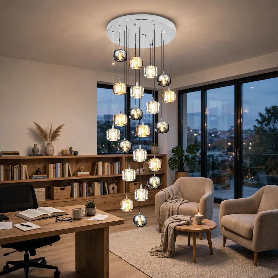 A modern multi-light chandelier with multiple glass cylindrical pendant bulbs hanging from a circular ceiling mount in a stylishly decorated home office and lounge area.