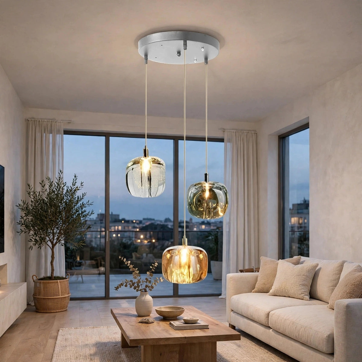 Three-light chandelier with clear, smoky, and amber crystal shades hangs from a round silver canopy above a wooden living room coffee table.