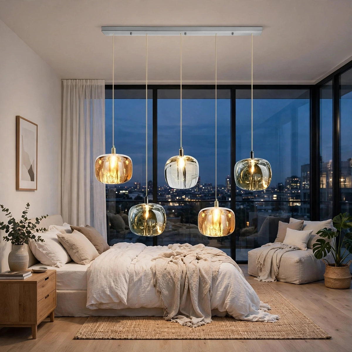 A five-light linear chandelier with amber, clear, and smoky crystal shades hangs above a cream bed beside corner windows.