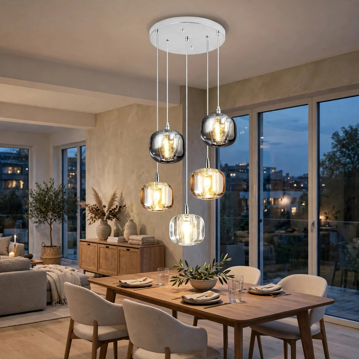 A modern multi-light pendant chandelier with five clear glass dropper globes and warm white LED bulbs, hanging over a wooden dining table in a contemporary living space.