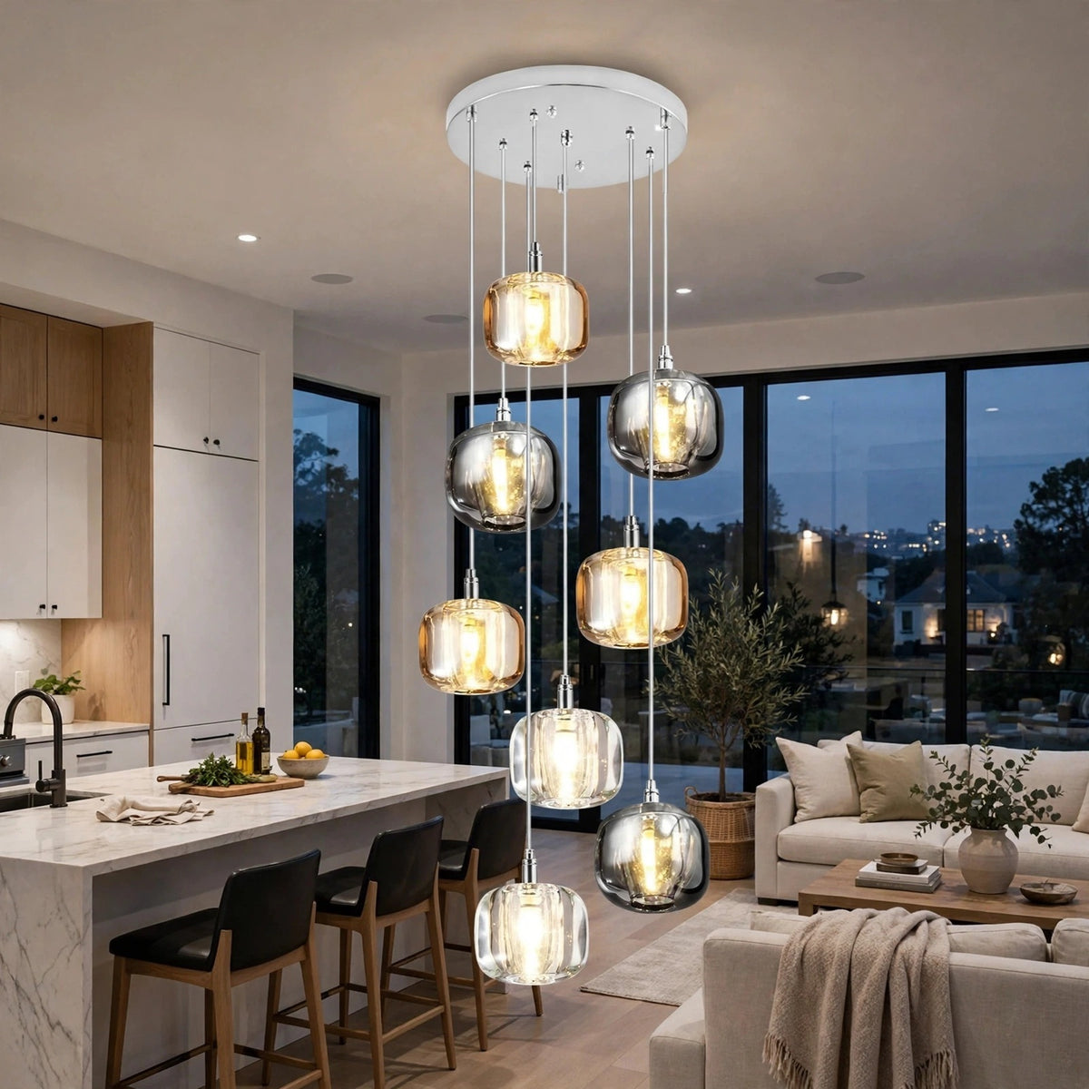 A modern multi-light pendant chandelier with six glass dome shades in silver and clear finishes, illuminated with warm yellow light, hanging in a contemporary kitchen and living room setting.