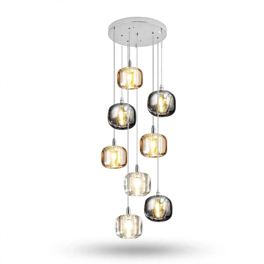 A chandelier has eight illuminated amber, smoky grey, and clear shades staggered beneath a round silver canopy against a white background.