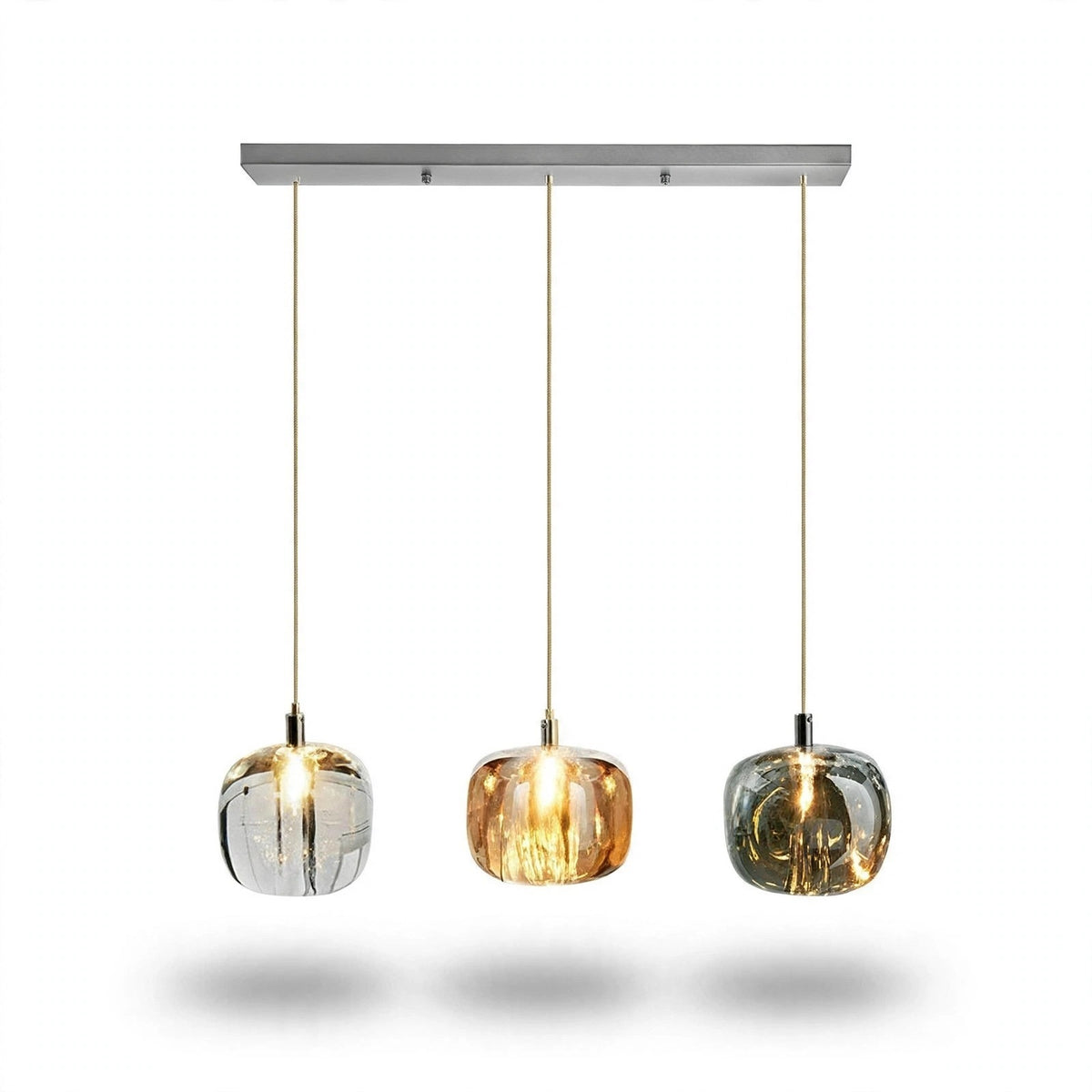 A linear chandelier has three illuminated clear, amber, and smoky grey shades in an even row beneath a rectangular silver canopy against white.