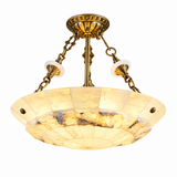 An Art Deco style semi-flush mount ceiling light fixture featuring a warm brass/gold metal frame, hanging chains, and a scalloped glass shade with a warm yellow and cream marbled pattern.