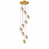A modern multi-light linear chandelier with a brushed gold circular ceiling canopy, gold-finished caps, and faceted clear glass pendant globes suspended on thin cords against a plain white background.