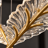 Close-up of the chandelier’s clear, ridged acrylic feather pendant with a gold-tone central stem against a dark background.