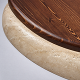 Close-up of a flush mount light showing dark brown wood grain and a textured beige travertine rim against a light grey background.