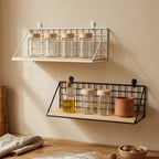 Black and white wall mounted spice racks hung one above the other on a kitchen wall, holding glass spice jars